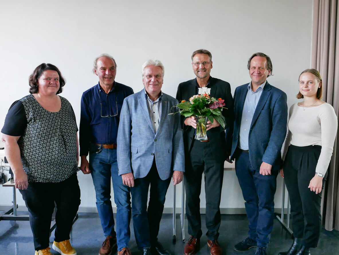 Gruppenfoto mit Wolfgang Behm mit Blumenstrauß in der Hand